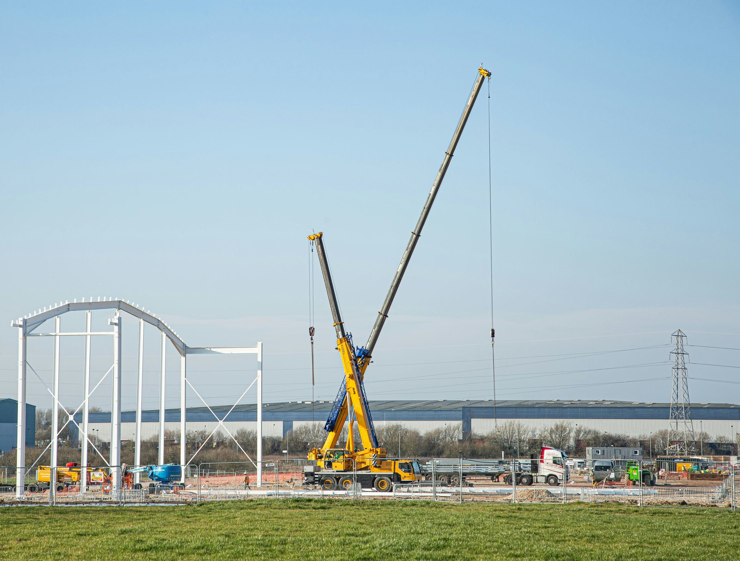 Mobile crane erecting a steel structure on an industrial project site